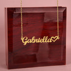 Name necklace in the color gold hanging from a luxury gift box from I Got You A Gift.