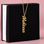 Custom name necklace designed to celebrate meaningful connections hanging on a black gift box. The color of it is gold.