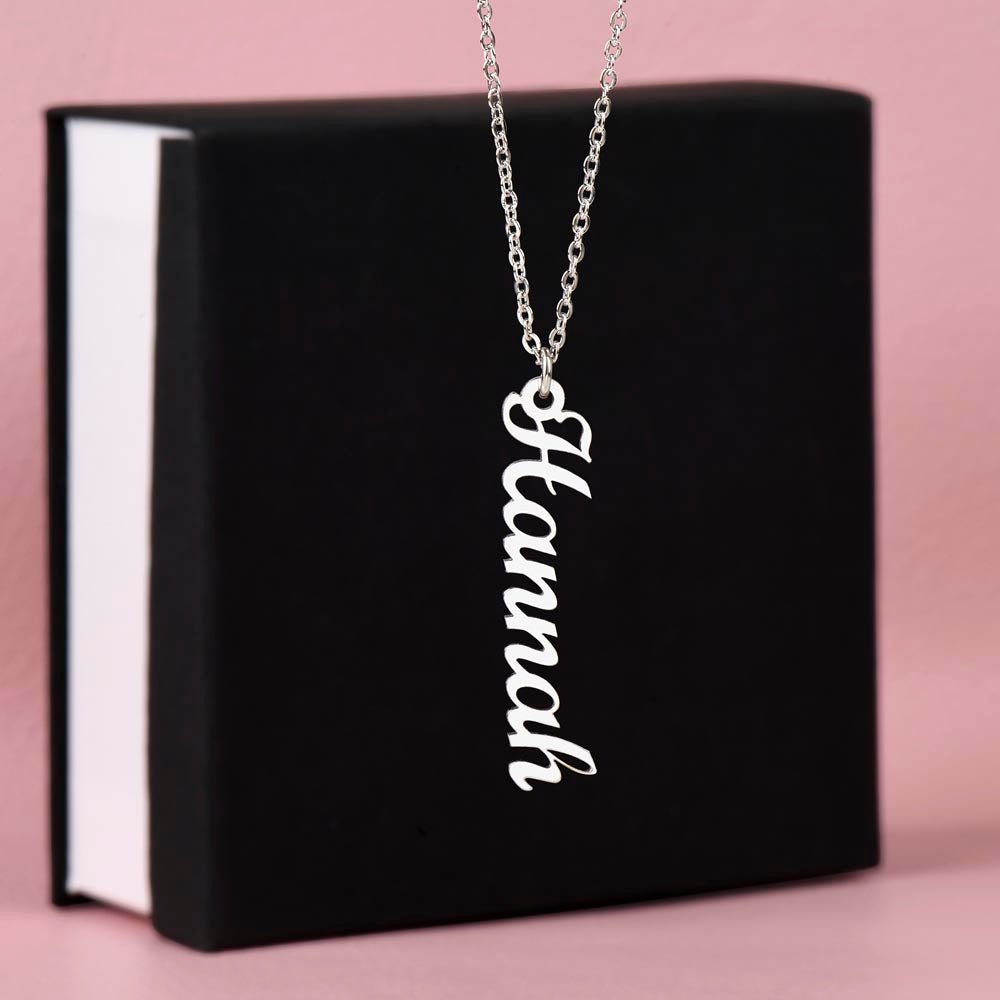 Custom name necklace designed to celebrate meaningful connections hanging on a black gift box.