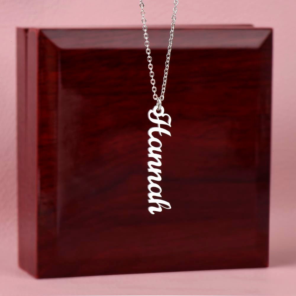 Custom name necklace hangind on display on a luxury gift box, the color is silver. The name on the necklace is Hannah.