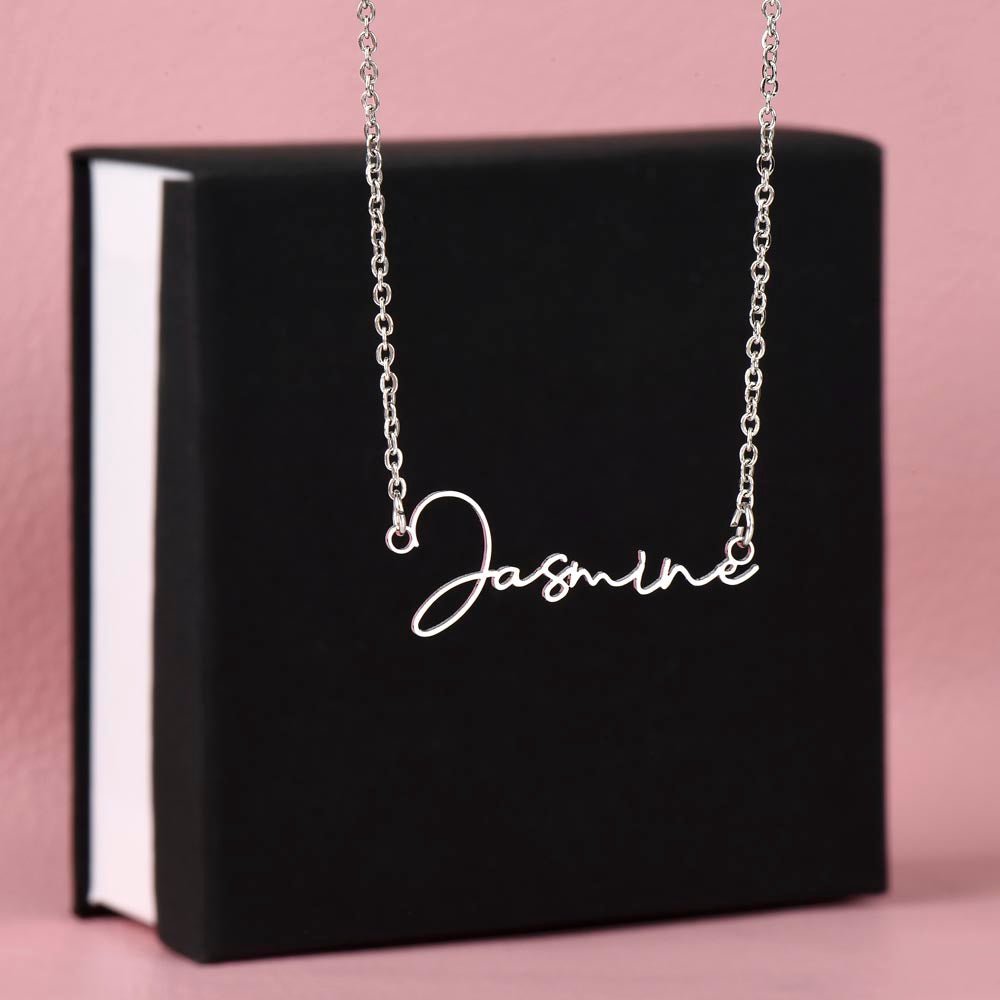 Custom name necklace hanging on display on a black gift box, the color is silver.